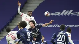 Bek Lyon, Sinaly Diomande (atas) melompat di antara para pemain Bordeaux untuk melepaskan sundulan ke gawang Bordeaux dalam laga lanjutan Liga Prancis 2020/21 pekan ke-22 di Groupama Stadium, Jumat (29/1/2021). Lyon menang 2-1 atas Bordeaux. (AP/Laurent Cipriani)