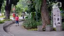 Warga berjalan di Taman Suropati, Menteng, Jakarta, Senin (21/12/2020). Pemerintah Provinsi DKI Jakarta mengeluarkan aturan mengenai pembatasan operasional tempat makan, hiburan, dan lokasi wisata selama libur Natal 2020 dan tahun baru 2021 hingga jam 21.00 malam. (merdeka.com/Dwi Narwoko)