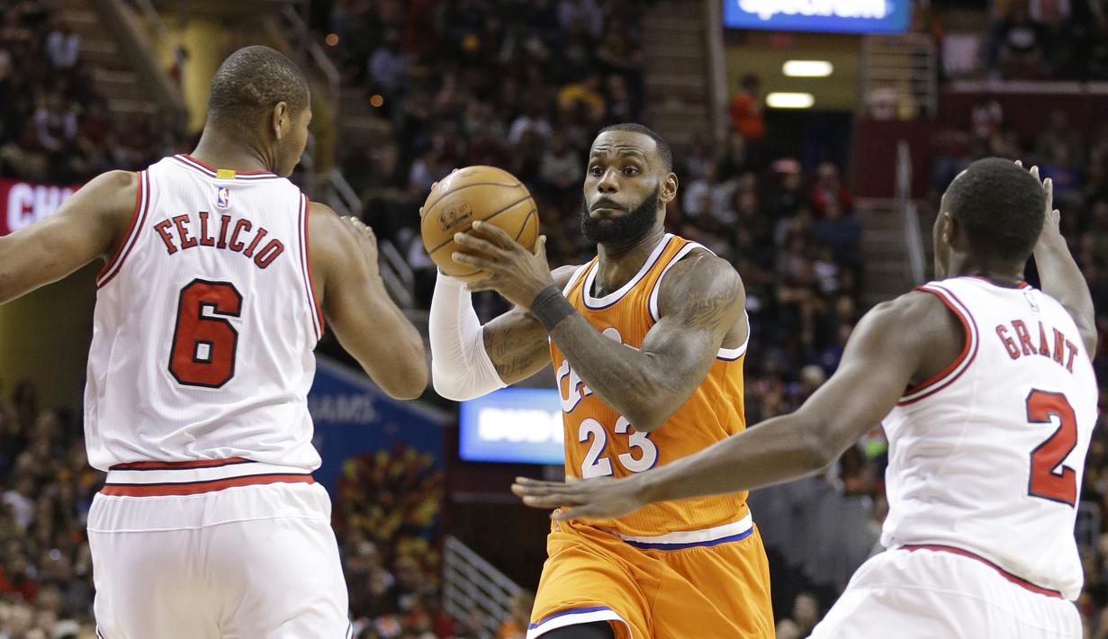 Pemain Cleveland Cavaliers, LeBron James (23) berusaha melewati hadangan para pemain Chicago Bulls pada aga NBA basketball game di Quicken Loans Arena, Cleveland. (AP/Tony Dejak)
