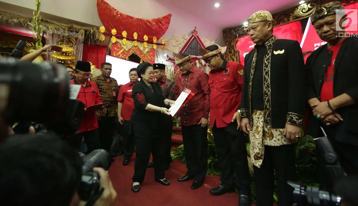 Ketum PDIP Megawati Soekarnoputri memberikan surat mandat kepada pasangan Dodi Reza dan  Giri Ramandan sebagai bakal calon gubernur dan wakil gubernur di Pilkada Sumatera Selatan 2018, Jakarta, Minggu (7/1). (Liputan6.com/Faizal Fanani)