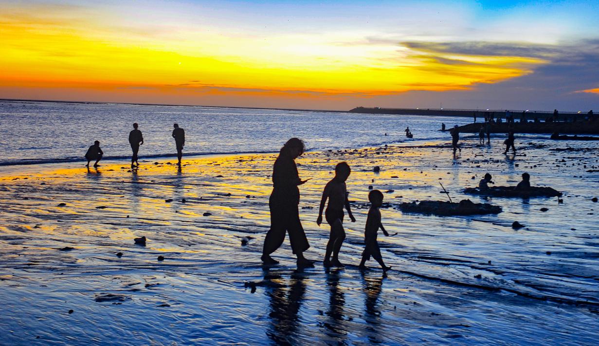 Pantai Kelan terbuka sepanjang waktu dan tidak mengenakan tiket masuk. Pengunjung hanya perlu membayar tarif parkir, yakni Rp2.000 untuk sepeda motor dan Rp5.000 untuk mobil. Meski dapat dikunjungi kapan saja, waktu terbaik menikmati pantai ini adalah pada sore hari saat panorama matahari terbenam menampilkan pesonanya yang paling memukau. Tampak dalam foto, aktivitas wisatawan menikmati waktu senja di Pantai Kelan, Badung, Bali. (merdeka.com/Arie Basuki)