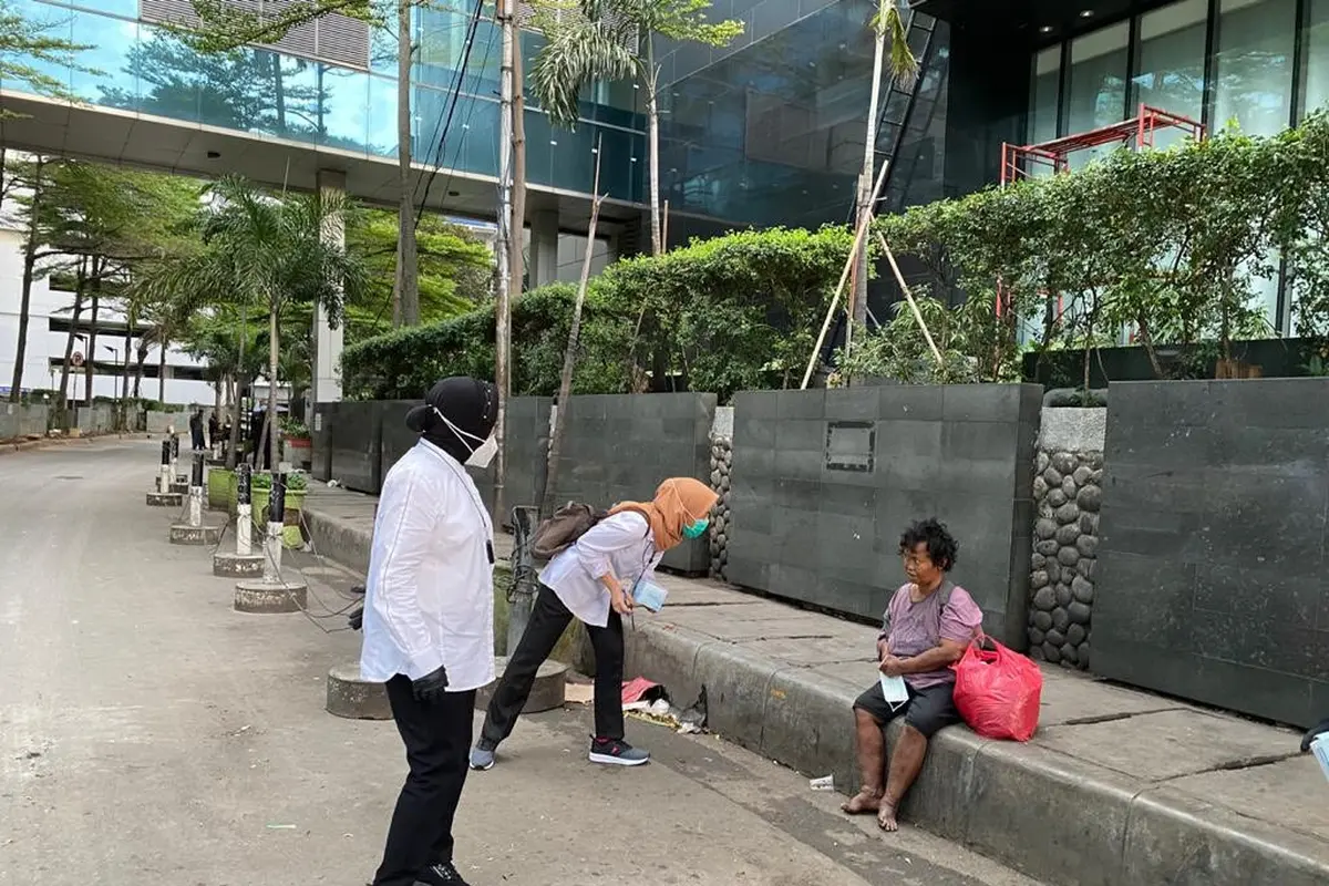 Menteri Sosial Tri Rismaharini atau Risma menyapa tunawisma di Jalan Sudirman, Jakarta Pusat, sebelum bekerja