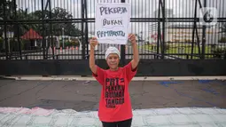 Salah satu peserta aksi yang tergabung dalam Koalisi Sipil Untuk UU Perlindungan PRT mengangkat poster di depan Gedung DPR, Jakarta, Rabu (15/7/2023). Dalam aksinya, pendemo yang sebagian besar ibu-ibu ini juga membawa spanduk dan poster berisi tuntutan mereka. (Liputan6.com/Faizal Fanani)
