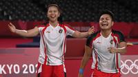 Pasangan Indonesia, Apriyani Rahayu dan Greysia Polii (kiri) merayakan kemenangan setelah pertandingan final bulu tangkis ganda putri melawan Jia Yifan dan Chen Qingchen dari China selama Olimpiade Tokyo 2020 di Musashino Forest Sports Plaza di Tokyo pada 2 Agustus 2021. (AFP/Alexander Nemenov)