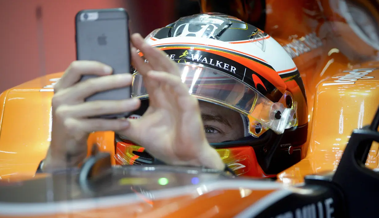 Pebalap McLaren asal Belgia, Stoffel Vandoorne menggunakan handphone untuk foto selfie saat sesi  latihan bebas F1 GP China di Shanghai, (6/4/2017). (AFP/Wang Zhao)