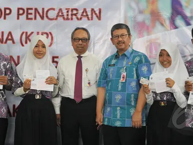 Kepala Dinas Pendidikan Arie Budhiman (kedua kanan) dan Direktur Utama Bank DKI Eko Budiwiyono bersama para siswa-siswi berfoto bersama usai memberikan Kartu Jakarta Pintar (KJP) di SMK 56 Pluit, Jakarta, Kamis (21/5/2015).(Liputan6.com/Herman Zakharia)