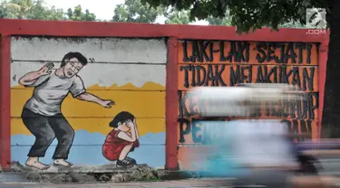 Pengendara melintasi mural bertema 'Tolak Kekerasan Perempuan dan Pelecehan Seksual' di kawasan Jatinegara, Jakarta, Senin (17/12). Mural tersebut dibuat untuk meningkatkan kesadaran akan ancaman bahaya pelecehan seksual. (Merdeka.com/Iqbal S. Nugroho)