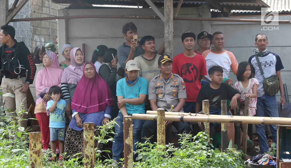 Warga berkerumun menyaksikan eksekusi bangunan rumah milik warga yang terdampak proyek Jalan Tol Cijago di kawasan Kukusan, Depok, Jawa Barat, Rabu (12/12). Di Kukusan, PN Depok kembali mengeksekusi 20 bidang lahan. (Liputan6.com/Immanuel Antonius)