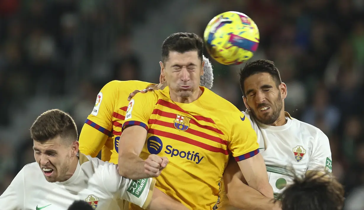 Penyerang Barcelona,  Robert Lewandowski (tengah) menyundul bola saat bertanding melawan Elche pada pertandingan lanjutan La Liga Spanyol di Stadion Martinez Valero di Elche, Spanyol, Sabtu,Minggu, 2 April 2023. (AP Photo/Alberto Saiz)