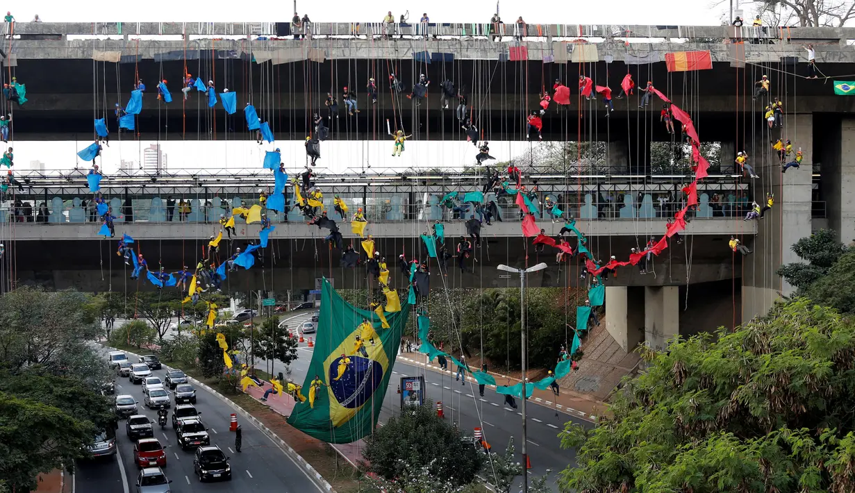 Pendaki profesional membuat Bentuk Cincin Olimpiade 2016 di sebuah jembatan di Sao Paulo, Brasil (31/7). Aksi ini dilakukan untuk menyambut dan memeriahkan Olimpiade 2016. (REUTERS/Paulo Whitaker) 
