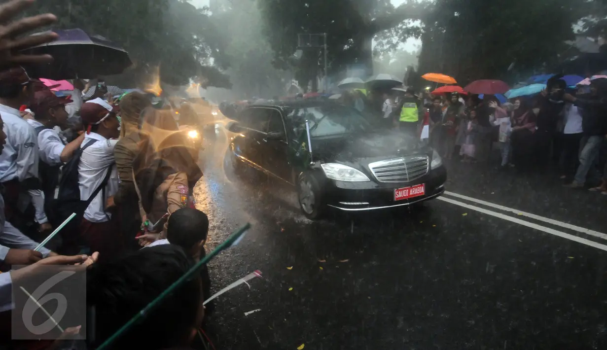 Pelajar dan warga menyambut kedatangan mobil bertuliskan Saudi Arabia di sekitar Istana Bogor, Rabu (1/3). Kedatangan Raja Salman bin Abdulaziz ke Istana Bogor disambut puluhan ribu pelajar dan warga. (Liputan6.com/Helmi Fithriansyah) 