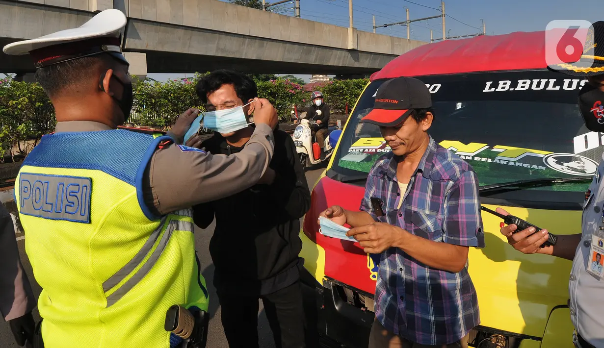 Petugas memberikan masker kepada pengendara selama Pemberlakuan Pembatasan Kegiatan Masyarakat (PPKM) Darurat di pos penyekatan Pasar Jumat, Jakarta, Sabtu (3/7/2021). Polda Metro Jaya menyiapkan 63 titik penyekatan selama penerapan PPKM Darurat di Jakarta dan sekitarnya. (merdeka.com/Arie Basuki)