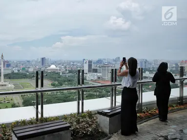 Pengunjung mengambil gambar pemandangan Monas dari atas Perpustakaan Nasional RI di Jakarta, Senin (6/11). Perpustakaan Nasional Indonesia (Perpusnas) yang baru ini di diresmikan Presiden Jokowi Pada 14 September 2017 lalu. (Liputan6.com/Faizal Fanani)