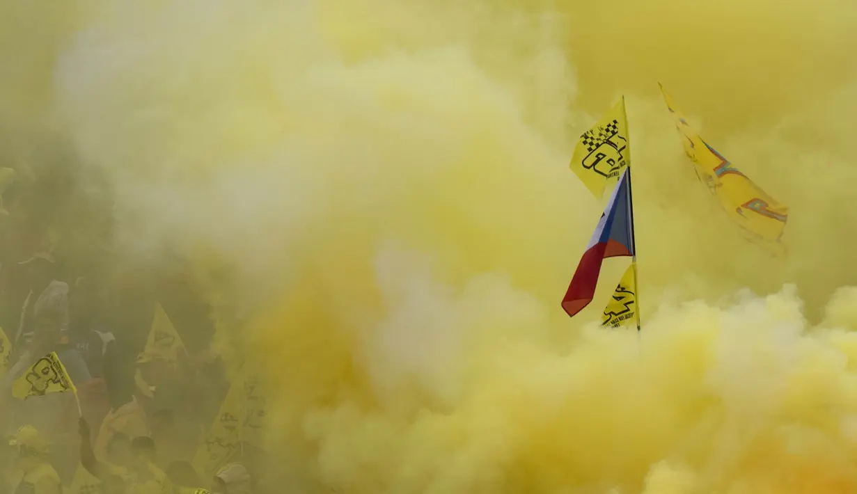 Sejumlah fans dari pebalap MotoGP, Valentino Rossi, menyalakan flare berwarna kuning ketika memberikan dukungan saat GP Ceska di Sirkuit Brno, Ceska, Minggu (21/8/2016). (AFP/Joe Klamar)