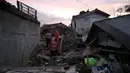Petugas memeriksa rumah yang rusak akibat gempa bumi di Ciheranhg Jaya, Pacet, Cianjur, Jawa Barat, Senin (21/11/2022). Longsor akibat gempa membawa sebuah angkot yang diduga berisi penumpang dan truk ke dalam jurang, evakuasi pun akan dilanjutkan esok hari. (merdeka.com/Arie Basuki)