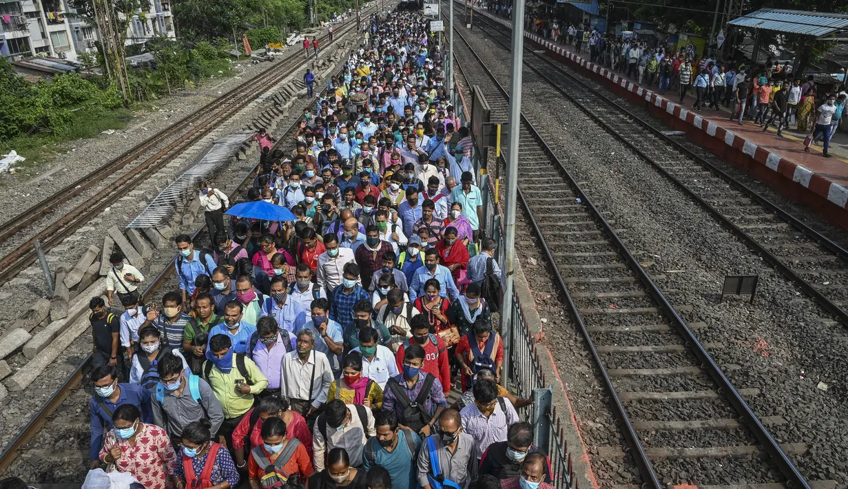 Komuter memadati peron kereta api di Kolkata, India, Senin (1/11/2021). Layanan kereta api kembali normal setelah menerapkan pembatasan yang diberlakukan sebelumnya untuk mengekang penyebaran corona Covid-19. (DIBYANGSHU SARKAR/AFP)