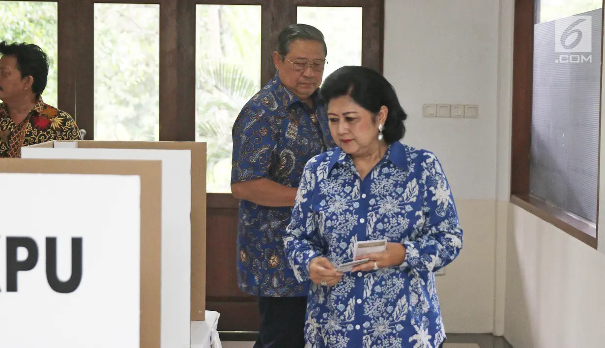 Presiden ke-6 RI Susilo Bambang Yudhoyono dan Ani Yudhoyono menuju bilik suara untuk mencoblos pada Pilkada Serentak 2018 di Tempat Pemungutan Suara (TPS) 06 Kelurahan Nagrak, Gunung Putri, Bogor, Rabu (27/6). (Liputan6.com/Herman Zakharia)