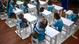 Seekor monyet mengangkat tangannya saat belajar di sekolah pelatihan kebun binatang di Dongying, China timur, 26 Januari 2016. Belasan monyet dilatih di sekolah itu sebagai bagian dari perayaan Tahun Monyet yang mulai pada 8 Februari (AFP PHOTO/WANG Zhao)