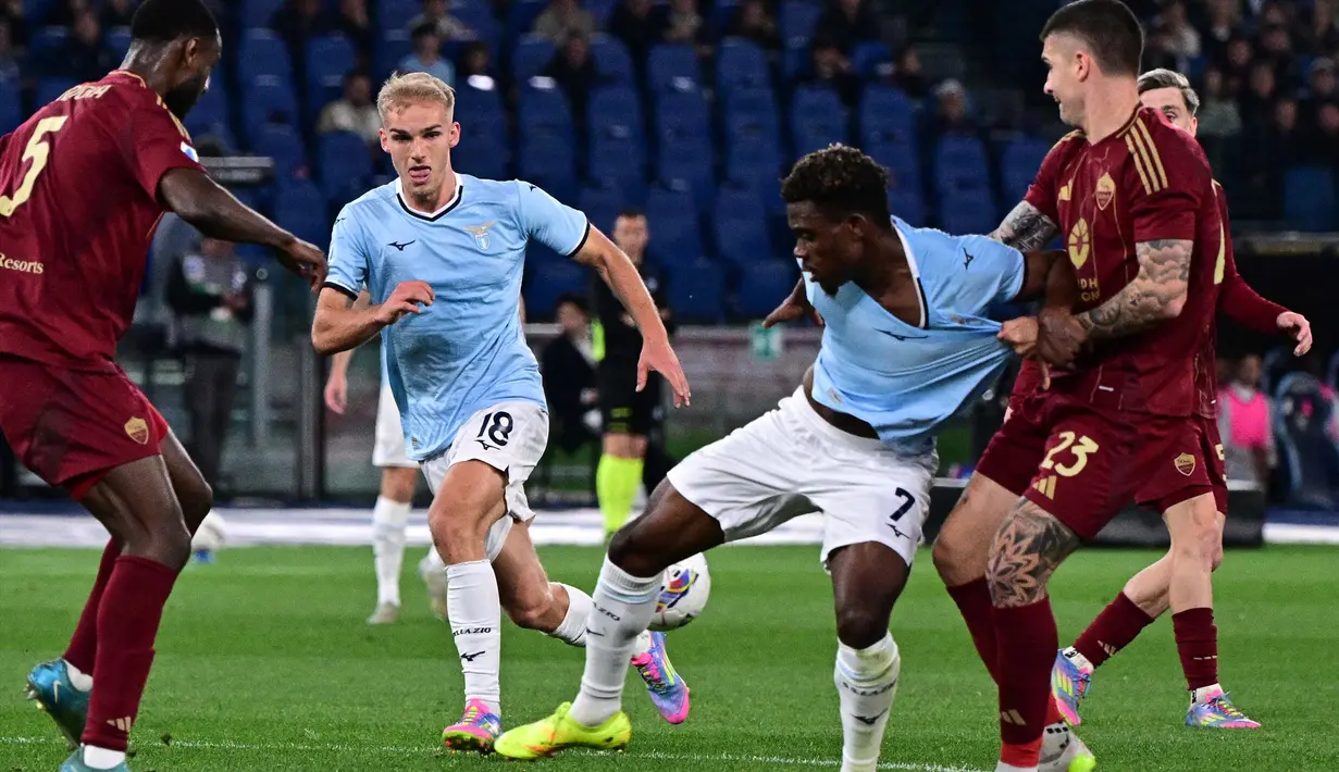 Gelandang Lazio, Fisayo Dele-Bashiru (kedua kanan) berebut bola dengan Gianluca Mancini (AS Roma) saat laga pekan ke-32 Serie A Italia musim 2024/2025 di Stadion Olimpico, Roma, 13 April 2025 atau Senin (14/4/2025) dini hari WIB. (Tiziana FABI/AFP)