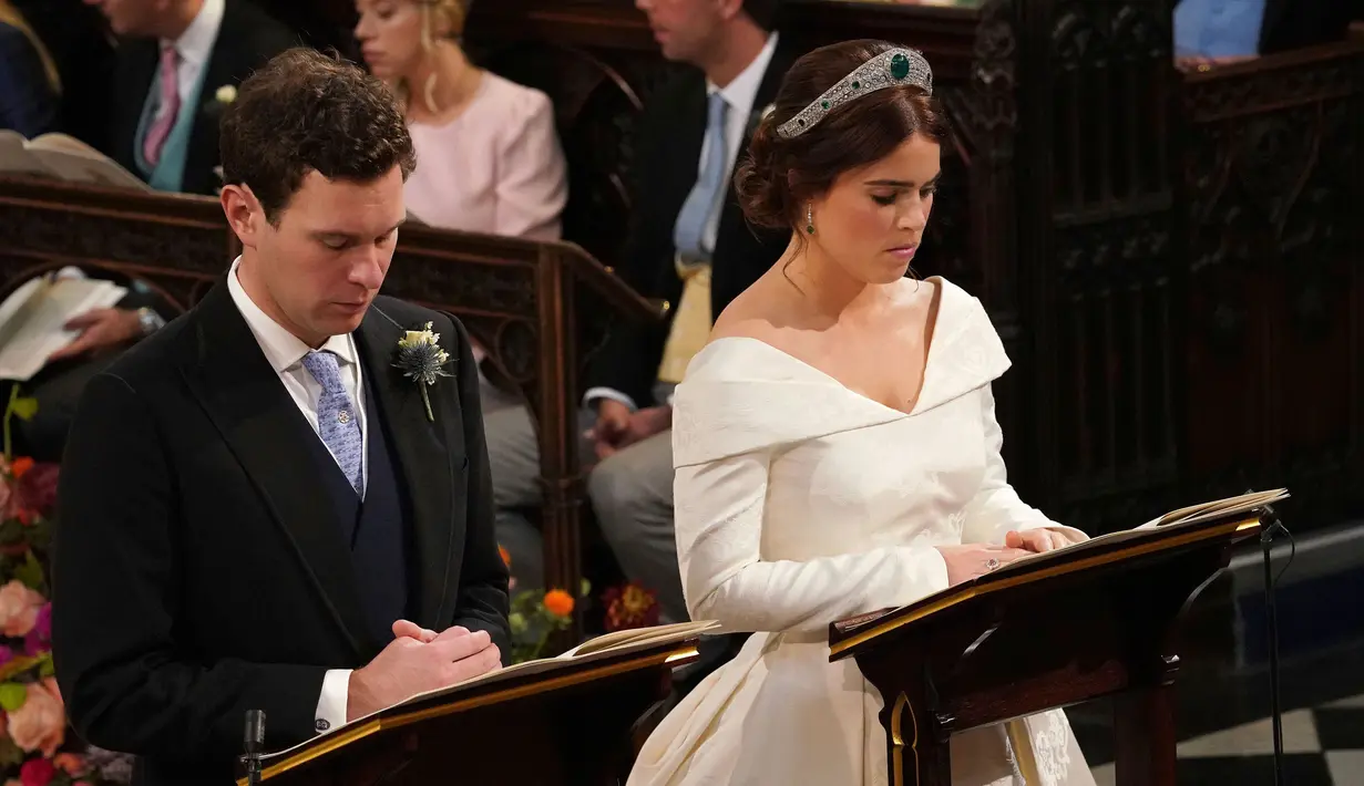 Putri Eugenie dan Jack Brooksbank saat melangsungkan proses pemberkatan nikah di Kapel St. George, Windsor Castle, London, Inggris,  Jumat (12/10). Pernikahan ini dihadiri Ratu Elizabeth II, bangsawan senior dan selebritas. (Jonathan Brady, Pool via AP)