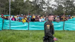 Para migran Venezuela menyaksikan sepak bola di kamp di Bogota, Kolombia (21/11). Pejabat kota menyelenggarakan turnamen sepak bola bagi migran yang tinggal di kamp yang dibangun badan kesejahteraan sosial kota tersebut. (AP Photo/Ivan Valencia)