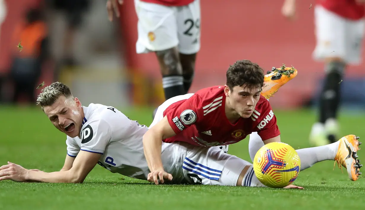 Gelandang Leeds United, Ezgjian Alioski (kiri) dan gelandang Manchester United, Daniel James, terjatuh usai perebutan bola dalam laga lanjutan Liga Inggris 2020/21 pekan ke-14 di Old Trafford Stadium, Minggu (20/12/2020). Leeds United kalah 2-6 dari Manchester United. (AFP/Nick Potts/Pool)