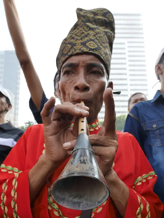 Masyarakat Maninjau Sumatera Barat memainkan pupuik Sarunai pada Parade Budaya Minangkabau di areal car free day, Jakarta, Minggu (8/7). Kegiatan ini untuk mensukseskan Festival Danau Maninjau pada Oktober 2018 mendatang. (Liputan6.com/Herman Zakharia)
