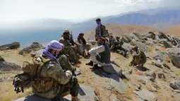 Gerakan perlawanan Afghanistan dan pasukan pemberontak anti-Taliban istirahat saat patroli di puncak bukit di daerah Darband, Distrik Anaba, Provinsi Panjshir, 1 September 2021. Panjshir terkenal dengan pertahanan alami yang tak pernah ditembus pasukan Soviet atau Taliban. (AHMAD SAHEL ARMAN/AFP)