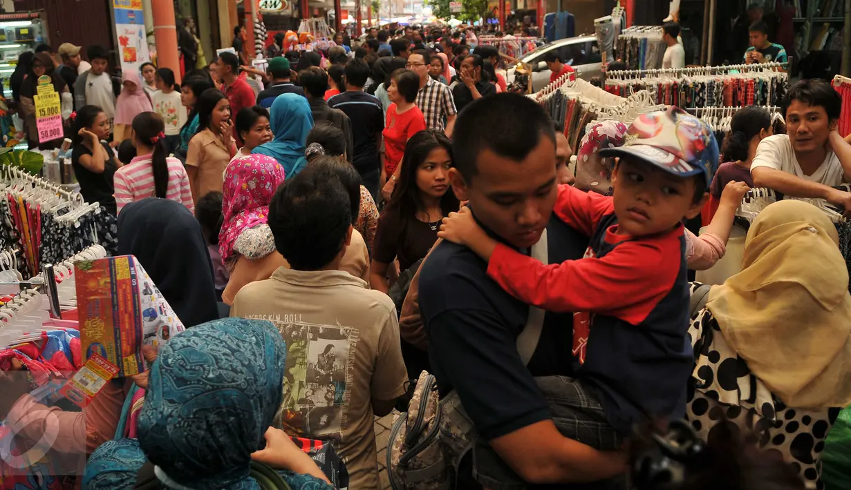 Warga memadati kawasan perbelanjaan Pasar Baru, Jakarta, Minggu (26/6). Menjelang lebaran sejumlah toko mulai memberikan potongan harga untuk menarik pembeli. (Liputan6.com/Gempur M Surya)