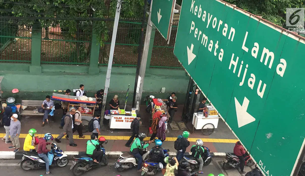 Pedagang kaki lima (PKL) dan ojek online memadati kawasan Stasiun Palmerah, Jakarta, Kamis (6/12). Kurangnya pengawasan petugas menyebabkan trotoar dan bahu jalan dipenuhi oleh PKL dan ojek online. (Liputan6.com/Immanuel Antonius)