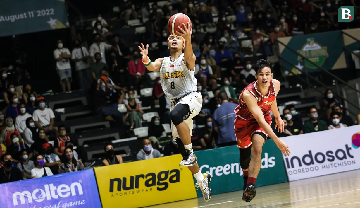 Aksi Yudha Saputera (kiri) saat melakukan lay up dan berusaha mencetak poin saat laga IBL All Star 2022. (Bola.com/Bagaskara Lazuardi)