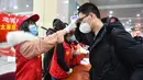 Sukarelawan memeriksa suhu tubuh mahasiswa Universitas Teknologi Taiyuan di Stasiun Kereta Selatan Taiyuan, Taiyuan, Provinsi Shanxi, China, Jumat (10/4/2020). Gelombang pertama mahasiswa dengan tugas penelitian di Shanxi mulai kembali menjalani perkuliahan. (Xinhua/Chai Ting)