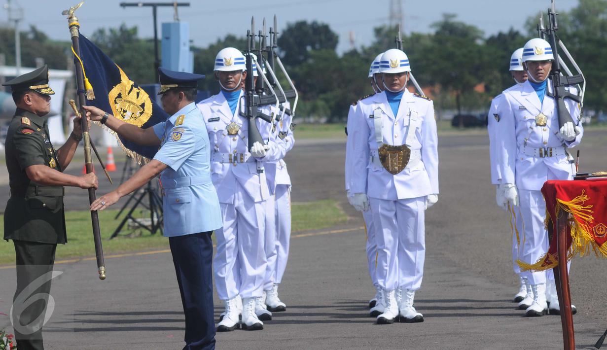 Masekal TNI Agus Supriatna‎ (kanan) menyerahkan pataka TNI AU ke Panglima TNI Jenderal Gatot Nurmantyo di Lanud Halim Perdanakusuma, Jakarta, Jumat (20/1). KSAU Marsekal TNI Agus Supriatna digantikan Hadi Tjahjanto. (Liputan6.com/Helmi Afandi)