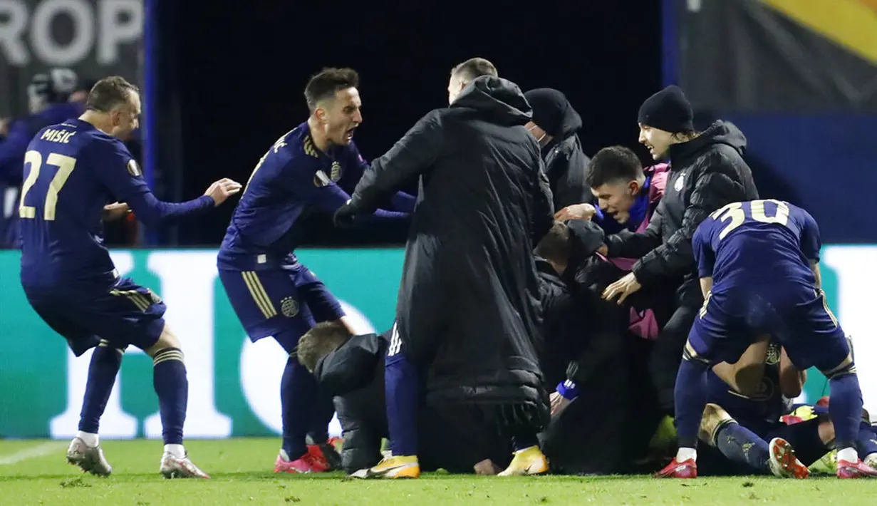 Para pemain Dinamo Zagreb merayakan dengan rekan setimnya Mislav Orsic usai mencetak gol ke gawang Tottenham Hotspur pada pertandingan leg kedua babak 16 besar Liga Europa di Stadion Maksimir, Zagreb, Kroasia (18/3/2021).  Tottenham kalah 0-3, sehingga agregat 2-3. (AP Photo/Darko Bandic)
