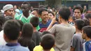Warga setempat  berebut mengajak foto bersama Makan Konate pemain Persib. (Bola.com/Peksi Cahyo)