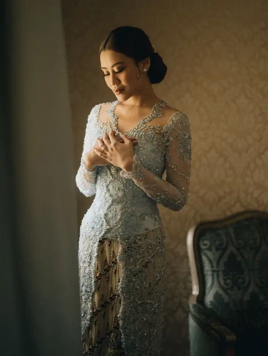 Rambutnya ditata dengan gaya sleek dan clean look; di-low-bun dan sedikit bagian ditempelkan di isi kanan-irinya, membingkai wajahnya dengan lebih apik. [Foto: Instagram/aaliyah.massaid]