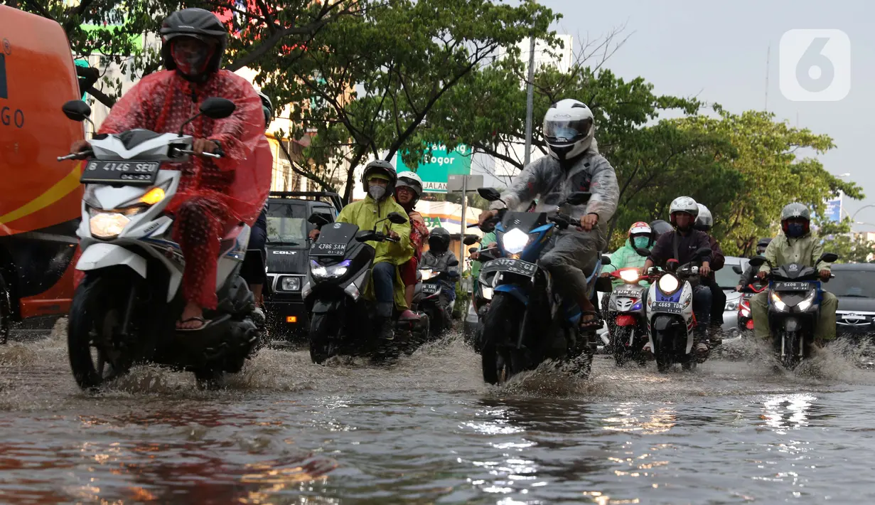 Pengendara melintasi jalan Margonda Raya yang tergenang air, Kota Depok, Jawa Barat, Jumat (29/5/2020). Hujan deras dan tersumbatnya aliran air menyebabkan sebagian ruas jalan Margonda Raya sempat tergenang air serta menyebabkan arus lalu lintas tersendat. (LIputan6.com/Helmi Fithriansyah)