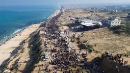 Puluhan ribu warga Palestina kembali dengan berjalan kaki melalui jalan di pesisir pantai menuju Gaza. (Foto oleh AFP)
