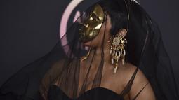Cardi B tiba di American Music Awards di Microsoft Theater di Los Angeles (22/11/20210). Topeng emas mencoloknya tersebut, ia padukan bersama gaun strapless hitam rancangan Schiaparelli. (AP Photo/Jordan Strauss)