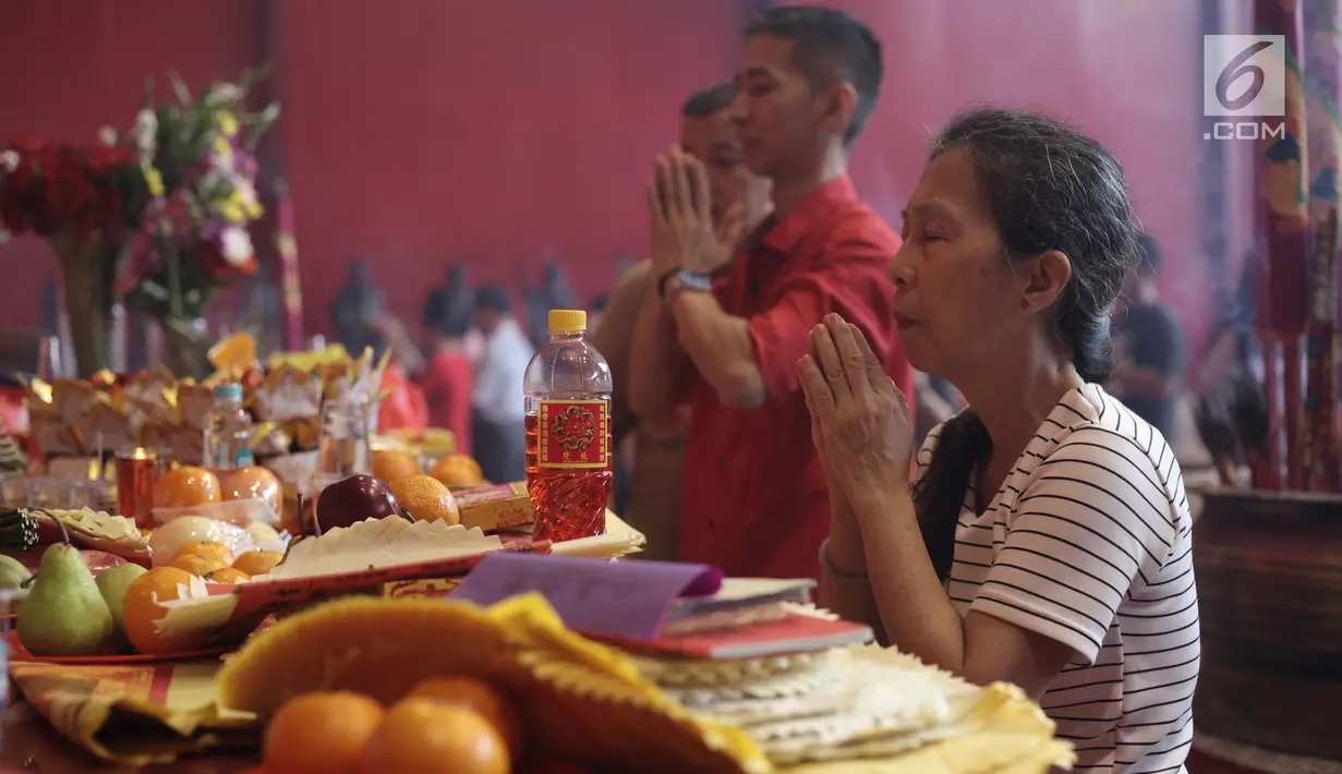 Warga keturunan Tionghoa memanjatkan doa pada perayaan Imlek 2569 di Vihara Dharma Bhakti, Petak Sembilan, Jakarta Barat, Jumat (16/2). Mereka melakukan ritual sembhayang dengan membakar dupa sambil berdoa untuk segala hal. (Liputan6.com/Arya Manggala)
