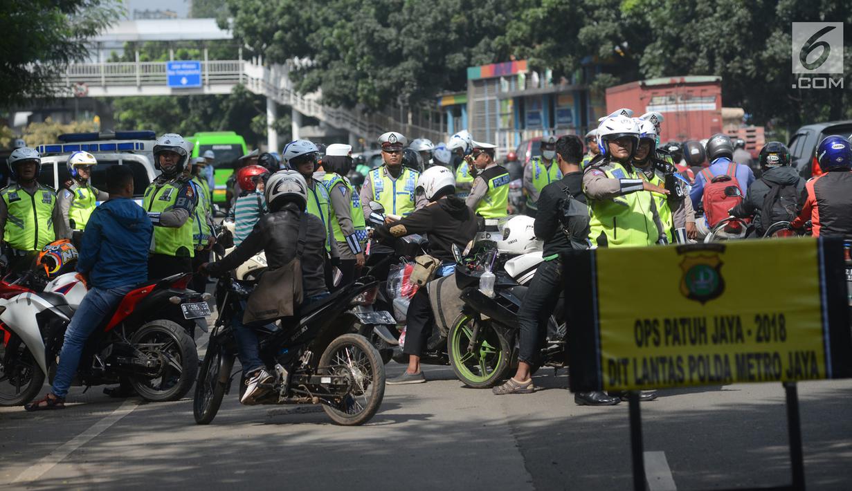 Polisi lalu lintas menggelar razia atau yang disebut Operasi Patuh Jaya 2018 di Jalan DI Panjaitan, Jakarta Timur, Jumat (27/4). Operasi ini bertujuan untuk menertibkan pengendara motor maupun mobil terhadap aturan lalu lintas. (Merdeka.com/Imam Buhori)