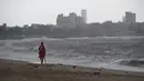 Penjaga pantai mengecek suasana pantai Girgaum Chowpatty setelah penutupannya saat awan gelap menyelimuti langit Mumbai (12/6/2019). Sebanyak hampir 300 ribu warga negara bagian Gujarat, India, akan dievakuasi menyusul adanya badai siklon Vayu. (AFP Photo/Punit Paranjpe)