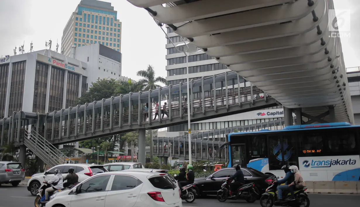 Masyarakat menggunakan sarana Jembatan Penyeberangan Orang (JPO) di Jalan Sudirman, Jakarta, Rabu (28/8/2019). Pemerintah Provinsi DKI Jakarta akan membangun 15 jembatan penyeberangan orang ( JPO) berkonsep modern atau futuristik pada 2020. (Liputan6.com/Faizal Fanani)