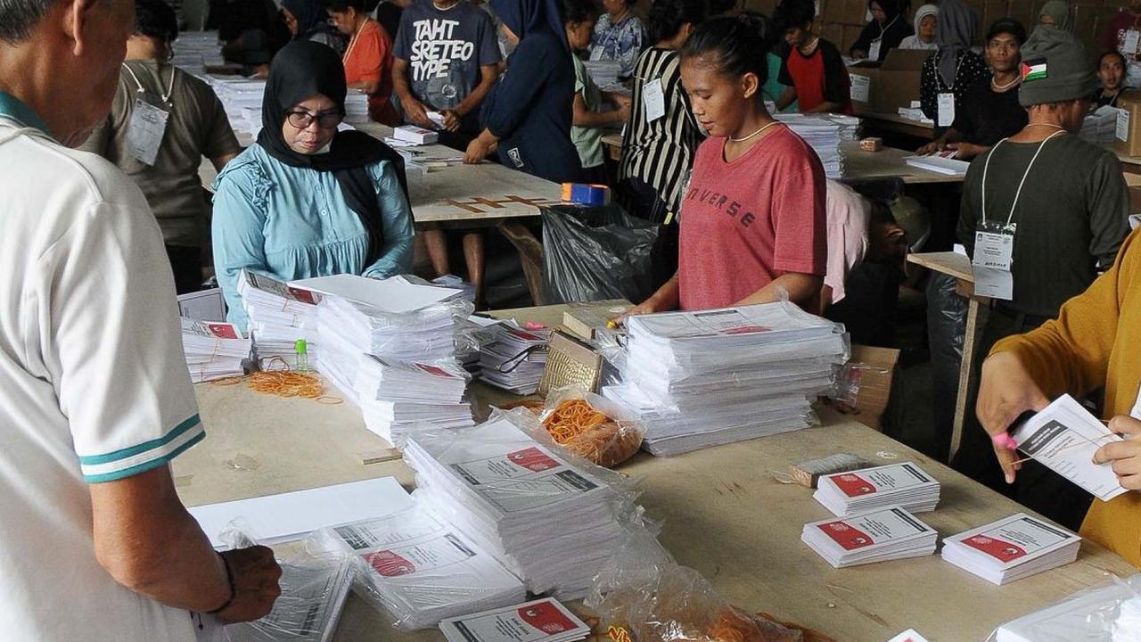 Aktivitas para pekerja saat melakukan pelipatan pada surat suara yang layak untuk dilipat setelah melalui tahapan sortir.<br>(merdeka.com / Imam Buhori)<br>