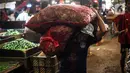 Pekerja memikul karung di Pasar Induk Kramat Jati, Jakarta, Kamis (29/12/2022). Rencananya, revitalisasi Pasar Kramat Jati ini akan selesai sekitar 18 bulan. (Liputan6.com/Faizal Fanani)