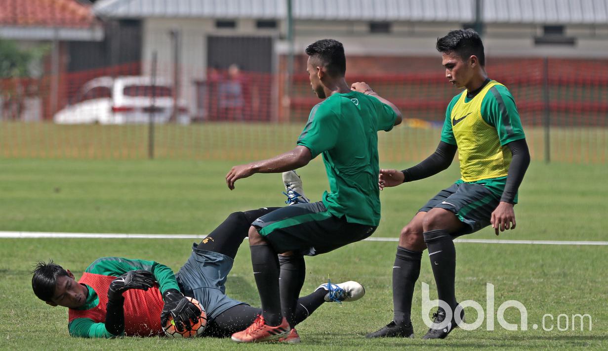 Aksi kiper Timnas U-22, Satria Tama mengamankan bola dari kejaran rekan-rekannya di Lapangan SPH, Karawaci, Jumat (17/3/2017). Timnas U-22 mempersiapkan diri melawan Myanmar pada laga persahabatan 21 Maret 2017. (Bola.com/Nicklas Hanoatubun)