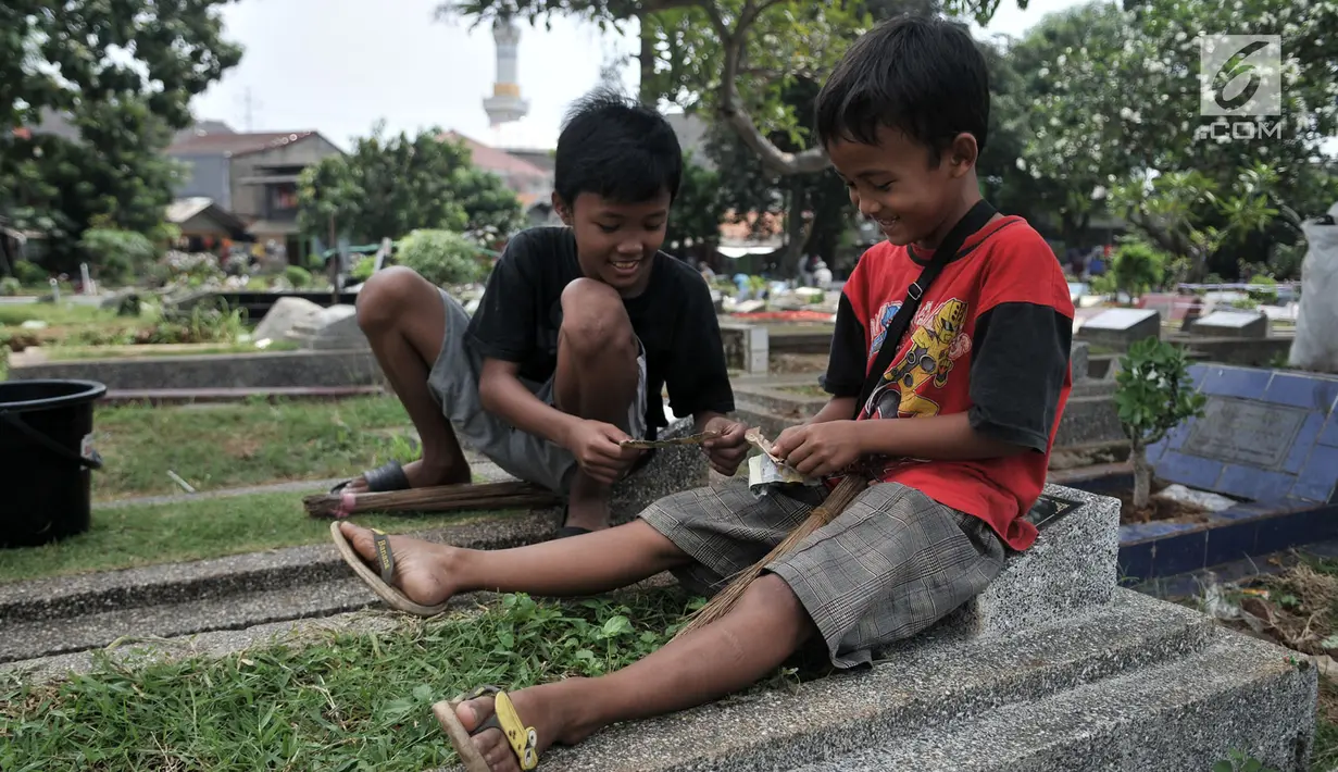 Sejumlah anak saat membagi hasil dari jasa 'Ngoret' makam di TPU Cipinang Baru, Jakarta, Minggu (5/5). Anak-anak 'Pengoret' makam mengaku dapat mengantongi uang hingga Rp 70 ribu dari hasil ngoret yang dimulai pagi sampai sore. (merdeka.com/Iqbal S. Nugroho)