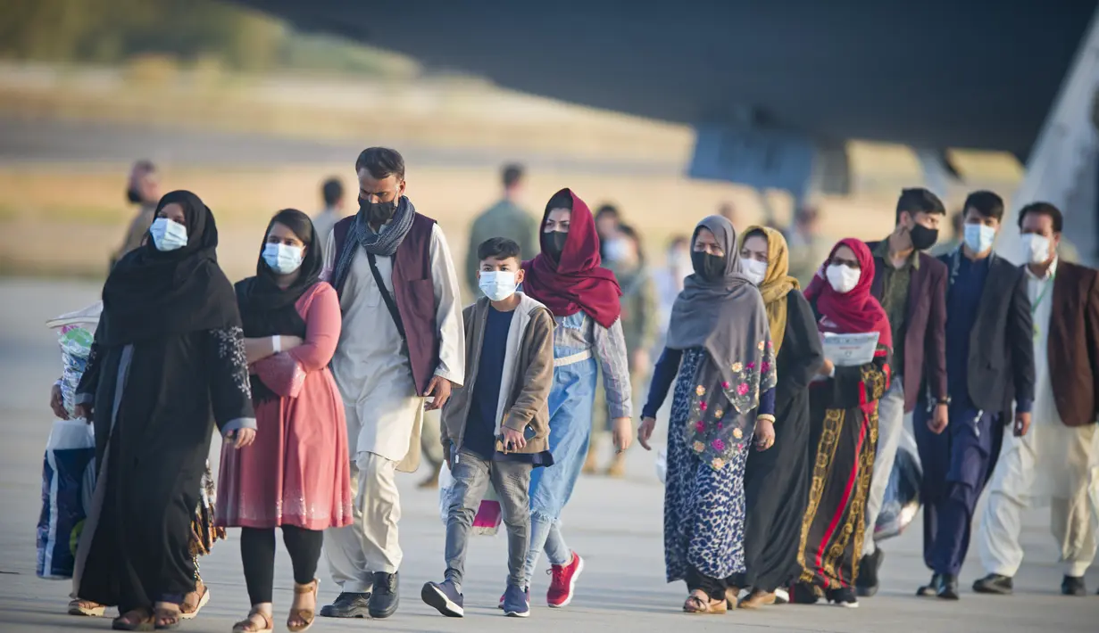 Pengungsi dari Afghanistan turun dari pesawat angkatan udara AS di Naval Station di Rota, Spanyol selatan, Selasa (31/8/2021).  Amerika Serikat menyelesaikan penarikannya dari Afghanistan Senin malam, mengakhiri perang terpanjang Amerika. (AP Photo/Marcos Moreno)