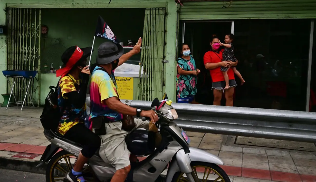 Demonstran menyapa warga saat melakukan konvoi dalam unjuk rasa di Bangkok, Thailand, Jumat (10/9/2021). Demonstran mendesak Perdana Menteri Thailand Prayut Chan-O-Cha mengundurkan diri atas penanganan pemerintah terhadap COVID-19 dan pembebasan tahanan politik. (LILLIAN SUWANRUMPHA/AFP)
