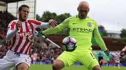 Kiper Manchester City, Willy Caballero, berusaha mengamankan bola dari jangkauan pemain Stoke, Ramadan Sobhi. Pelatih City, Pep Guardiola, kembali menjadikan Joe Hart sebagai cadangan dan memilih memainkan Caballero. (AFP/Lindsey Parnaby)